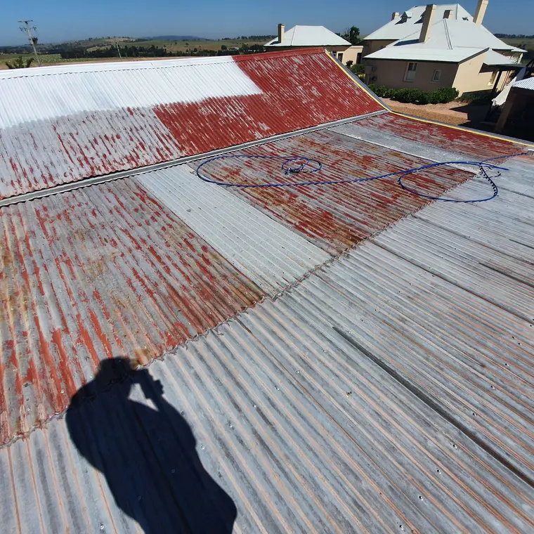 Weathered corrugated roof during preparation and coating