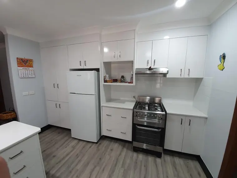 Kitchen cabinetry after repainting in a bright white finish