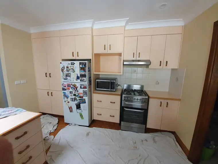Kitchen cabinetry before repainting in a beige finish