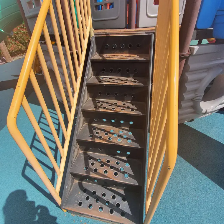 Rusty playground stairs before preparation and repainting