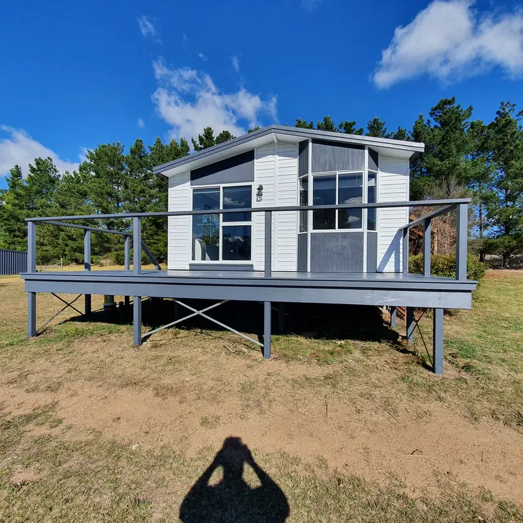 Small dwelling and deck after repainting in grey and white